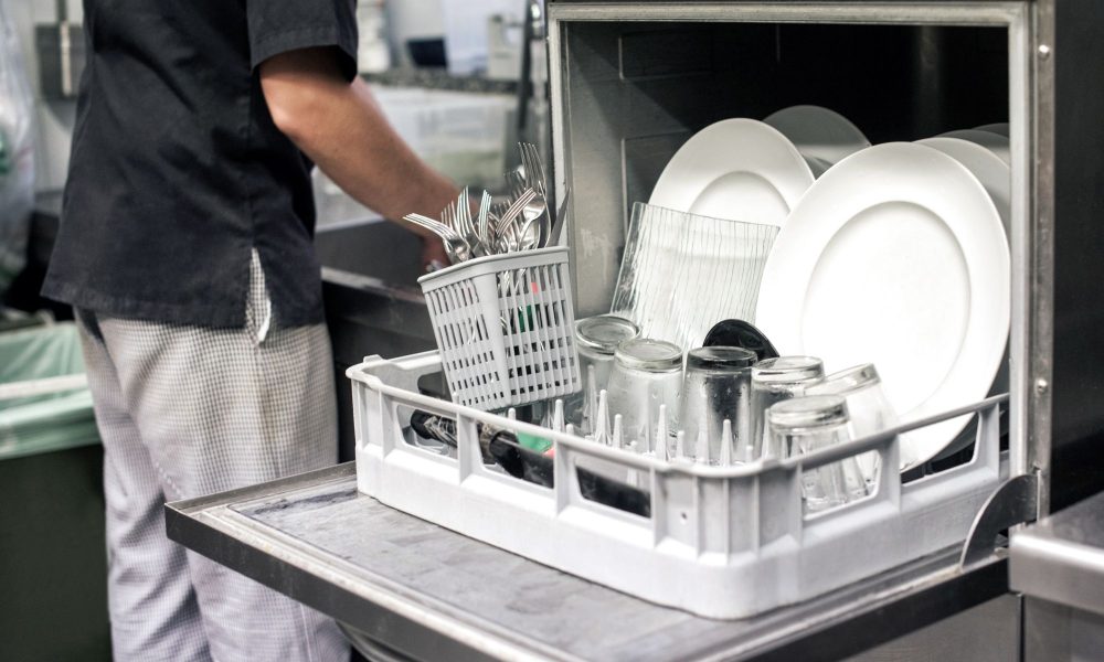 kitchen hand with an open dishwasher