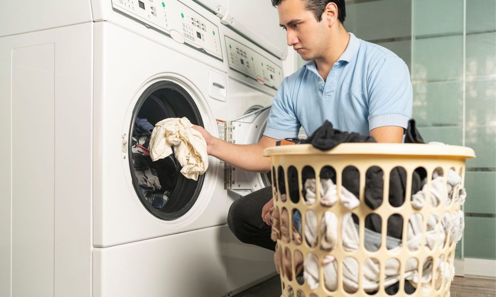 laundry employee putting clothes in the washer