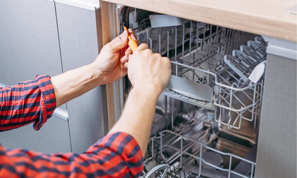 man repairing dishwasher male hand with screwdriver